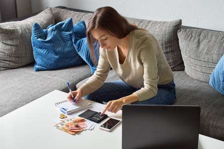 © Lukasz - stock.adobe.com Foto: Frau mit Taschenrechner und Bargeld