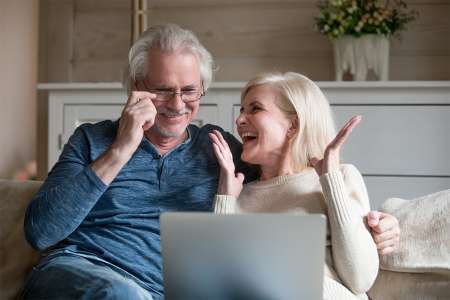 © fizkes - stock.adobe.com Foto: Zwei Pensionisten sitzen auf einer Couch mit einem Laptop